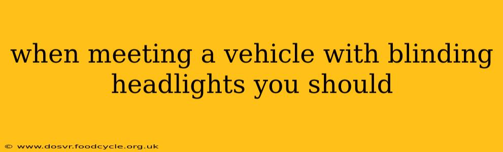 when meeting a vehicle with blinding headlights you should